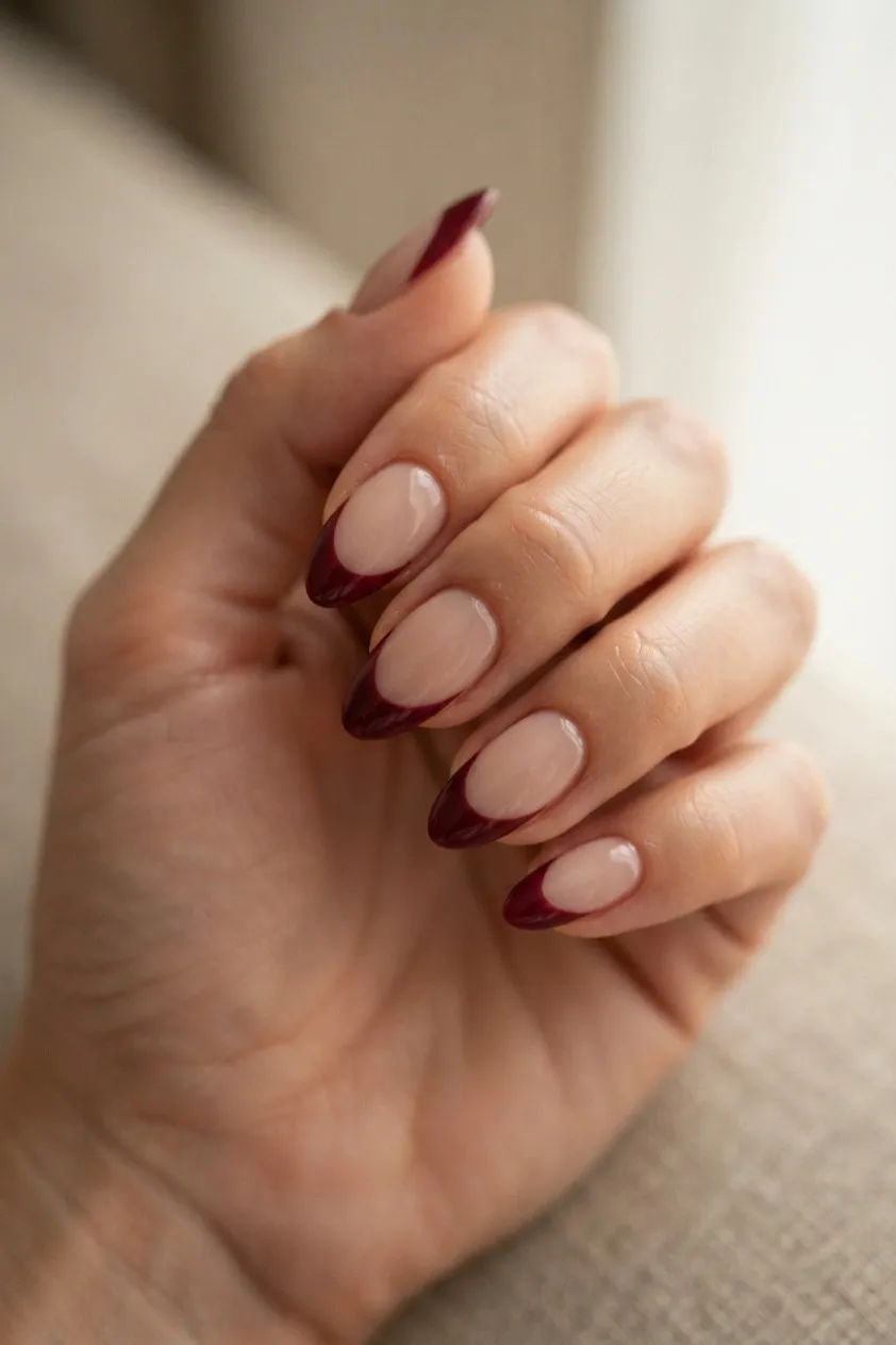 Almond nails with a burgundy French tip curved to follow the free edge