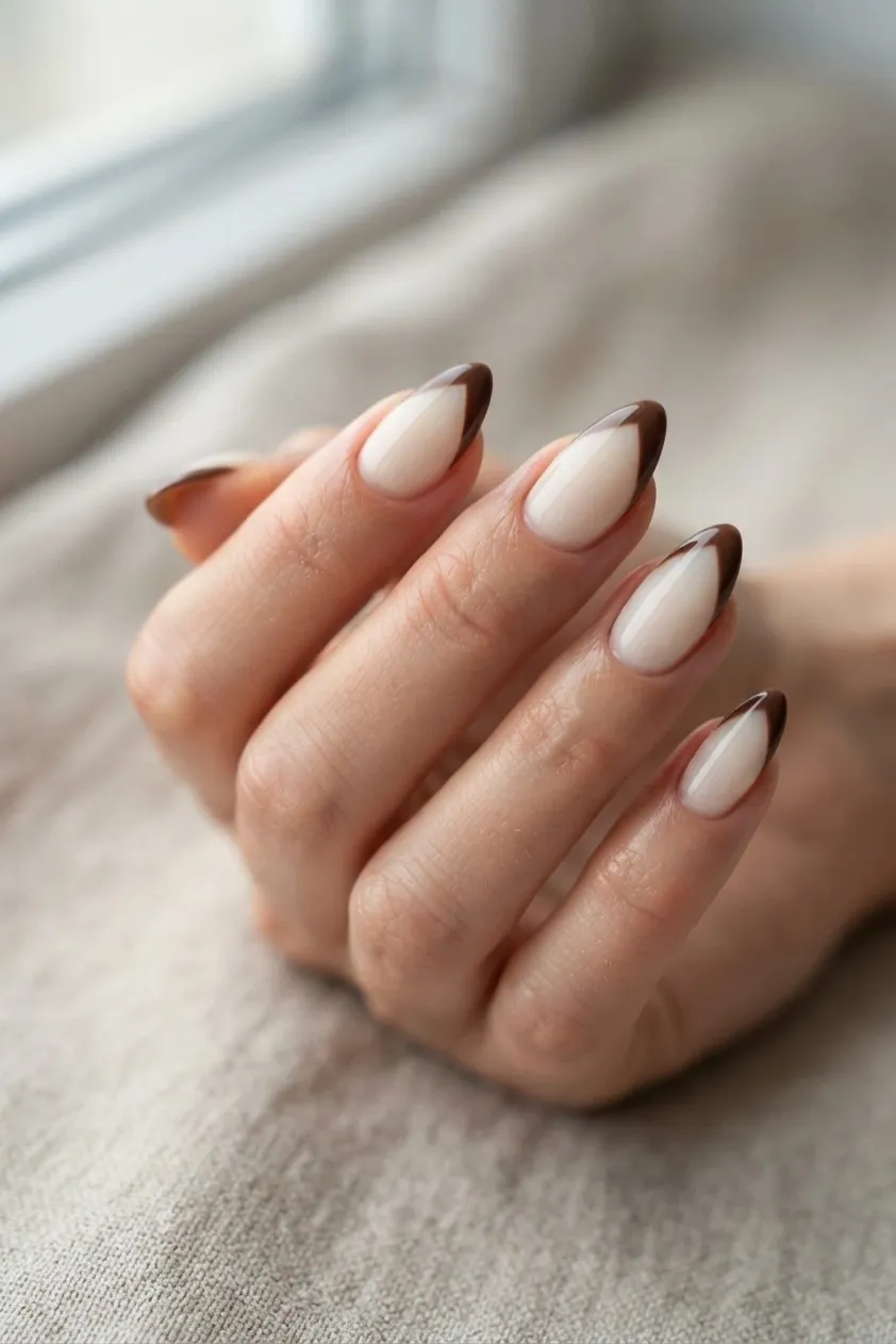 Cream almond nails with a chocolate brown V shaped tip