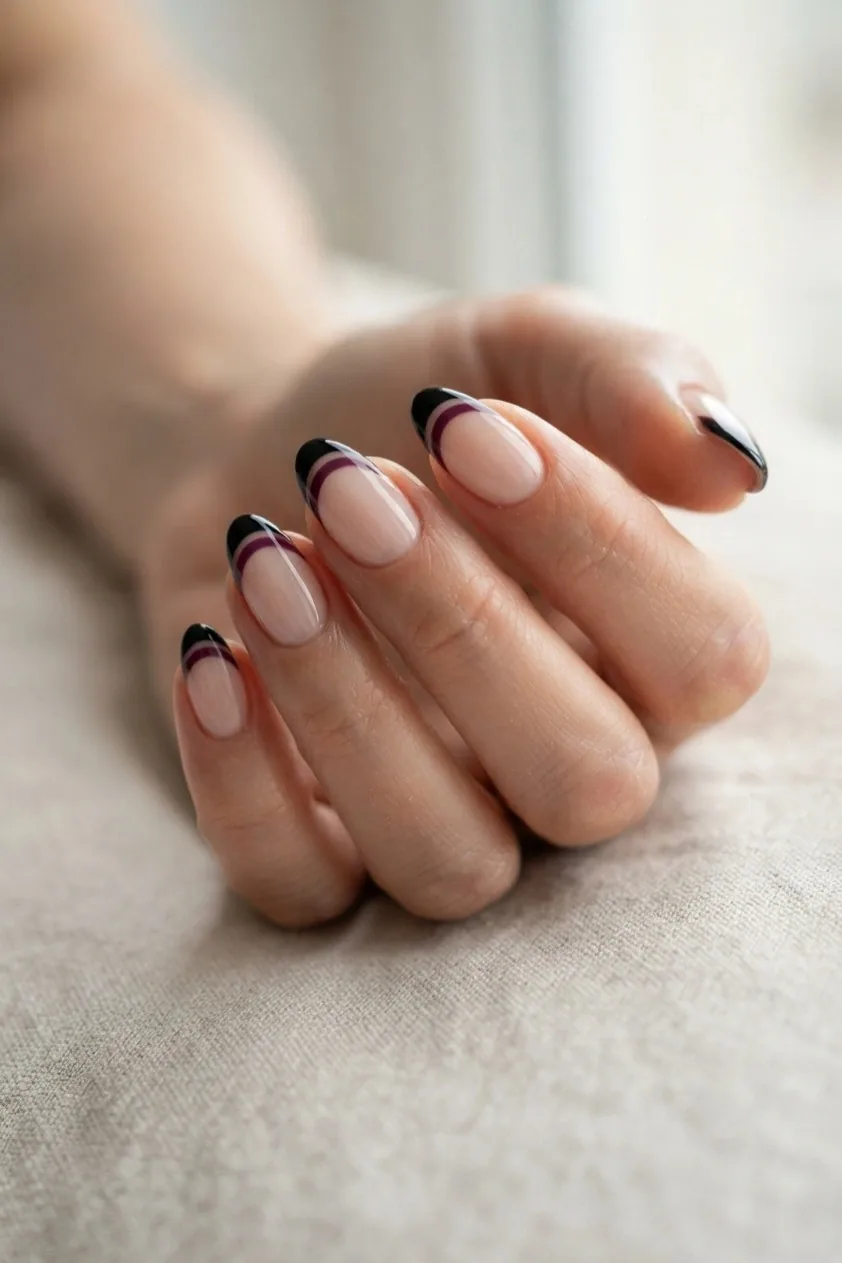 Nails with a double French tip in bright purple layered over black