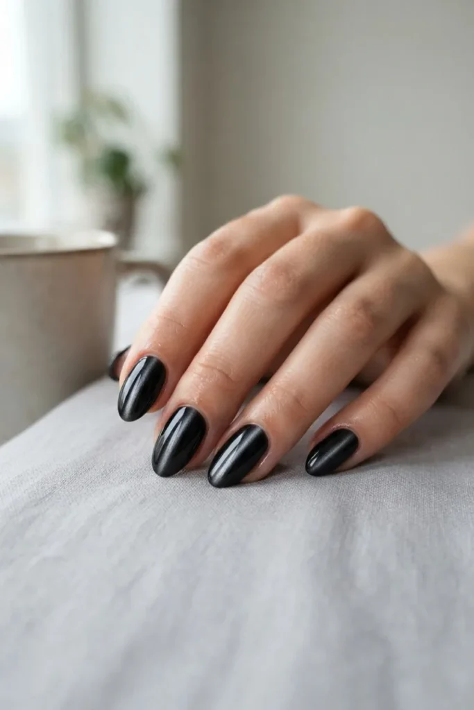 Black nails with a magnetic cat eye stripe of light down the center of each nail