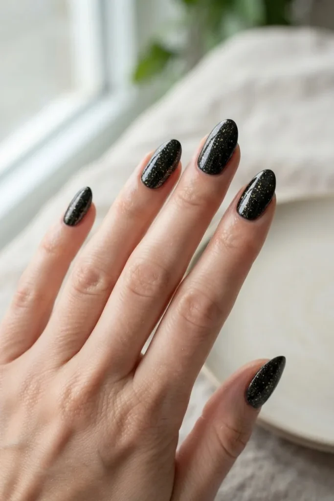 Black chrome nails with fine gold flecks suspended in the finish