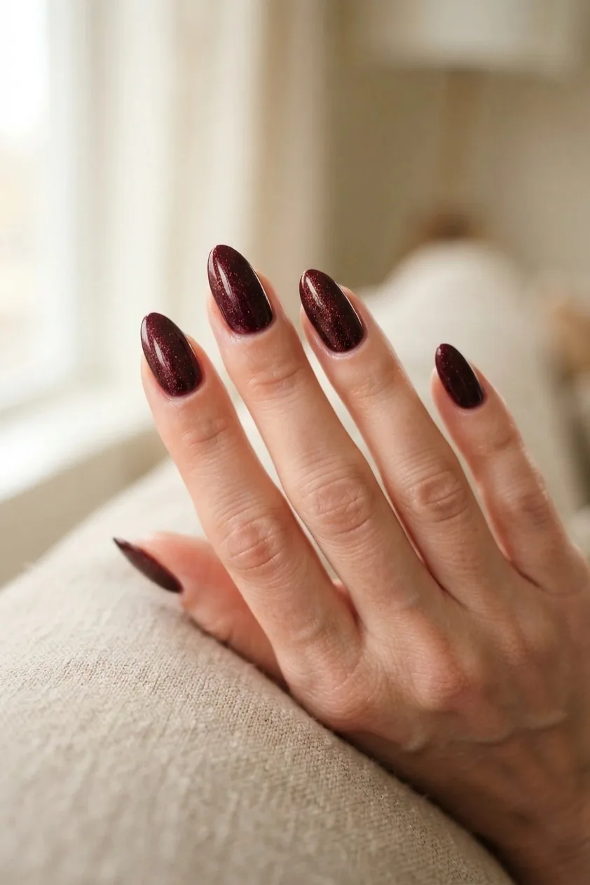Deep matte oxblood polish on medium length nails