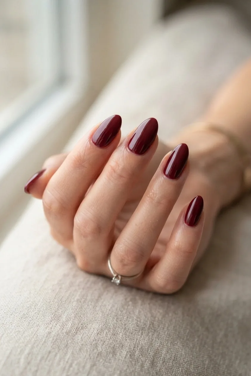 Wine and cream marble swirls across almond nails
