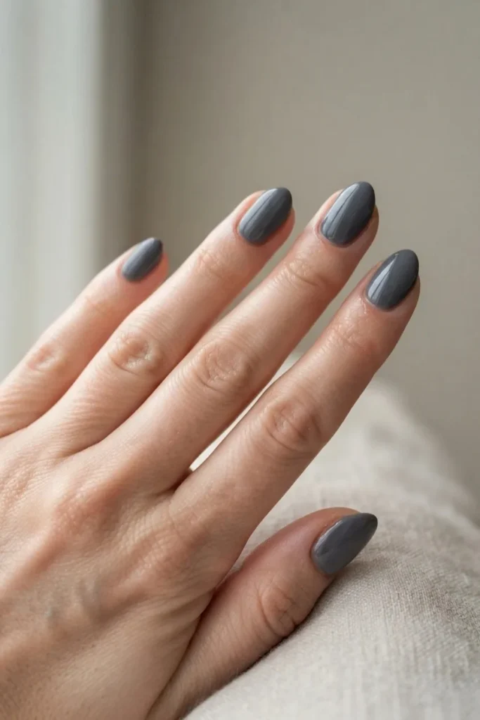Short almond nails in a cool charcoal gray creme polish