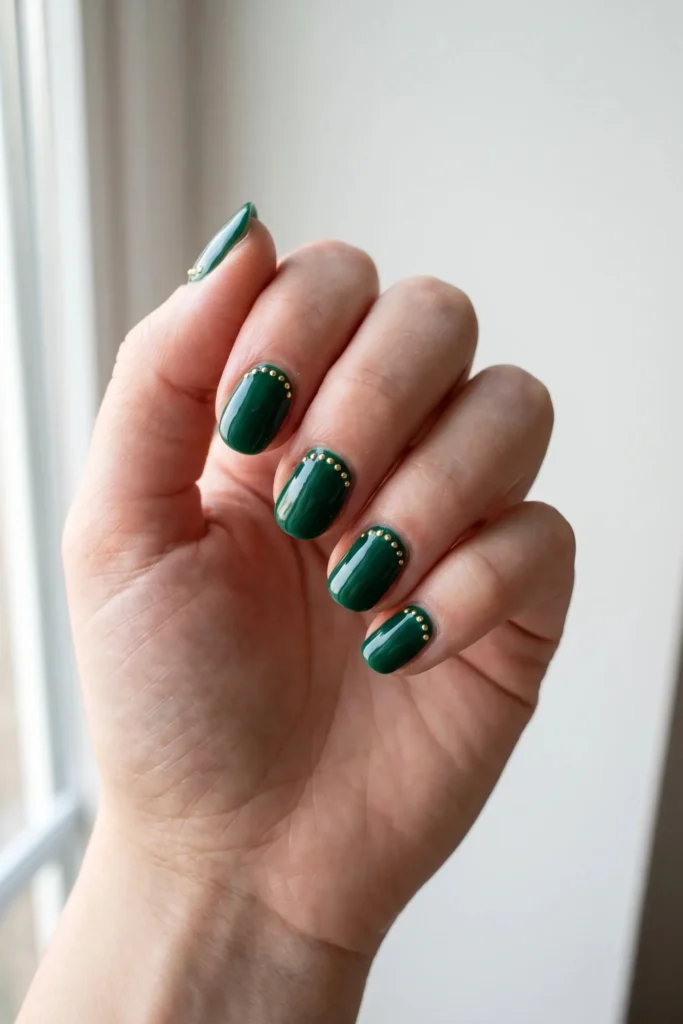 Green Christmas nails with a curved gold dot garland design